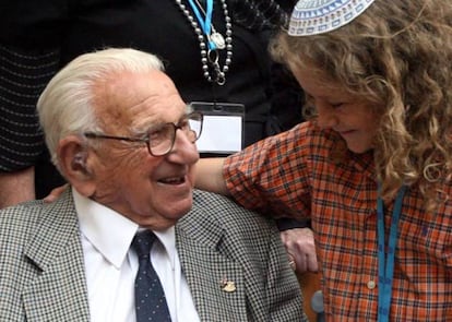 Sir Nicholas Winton sorri para um menino na estação Liverpool Street, em Londres, em 2009.