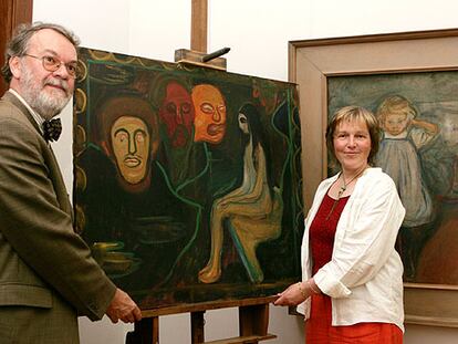 Wulf Herzogenrath y la restauradora Barbara Wiemer sostienen <i>Joven y tres cabezas de hombres,</i> de Munch.