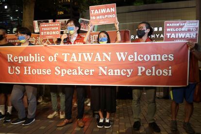 Simpatizantes de Nancy Pelosi sostienen carteles de bienvenida a la presidenta frente al hotel donde se hospedará, este martes.