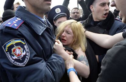 Agentes de la policía detienen a una activista de Femen ante el Parlamento de la república autónoma ucraniana de Crimea durante una protesta contra Putin.