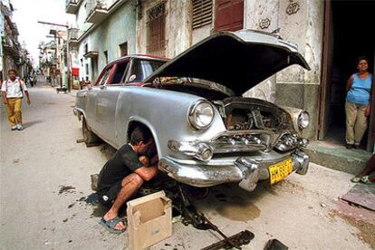 Un mecánico reparando un viejo modelo de un Plymouth en la calle del Valle en el centro de La Habana (2000).