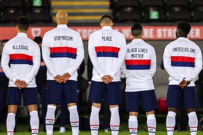 Jugadores de la selección de Estados Unidos con frases de justicia social estampadas en sus espaldas antes de un partido contra Gales en 2020.