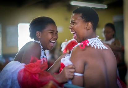 Dos participantes en las fiestas bromean mientras se preparan. En Sudáfrica, la ceremonia se conoce como Umkhosi woMhlanga, y tiene lugar en agosto o septiembre. Las chicas vienen de todas partes de Zululand, y en los últimos años también hay grupos más pequeños de Suazilandia, así como lugares más distantes como Botswana y Pondoland.