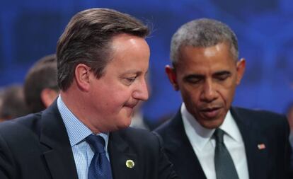 El primer ministro británico charla con el presidente Obama en Varsovia.