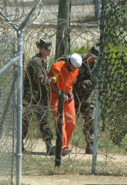 Dos militares de EE UU trasladan a un detenido para interrogarle en 2002.