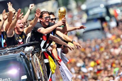 TOPSHOTS
German national football team players cheer as they ride in an open-deck bus to Berlin's landmark Brandenburg Gate to celebrate their FIFA World Cup title. Germany won their fourth World Cup title, after 1-0 win over Argentina on July 13, 2014 in Rio de Janeiro in the FIFA World Cup Brazil final game.   AFP PHOTO /  DPA /JAN WOITAS / GERMANY OUT