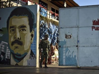 Un soldado venezolano, el pasado lunes, junto a un mural dedicado a Nicolás Maduro en la entrada de un colegio de Caracas.