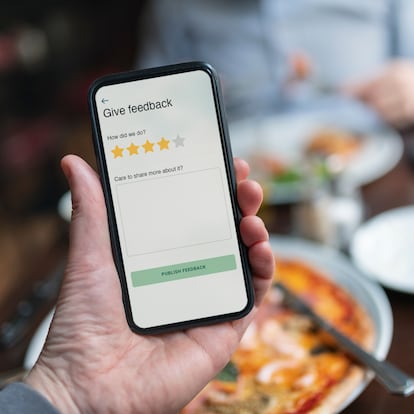 Person holding smart phone with restaurant rating app