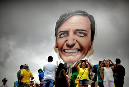 Seguidores del presidente electo de Brasil, Jair Bolsonaro, caminan frente a un muñeco gigante con su figura en la Explanada de los Ministerios, antes de su investidura, en Brasilia.