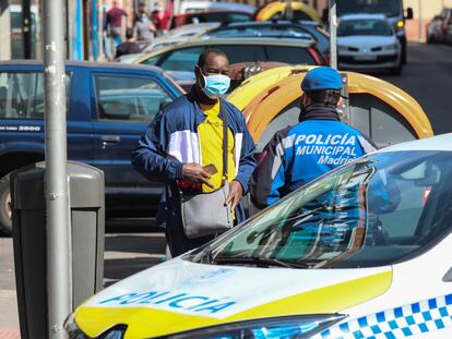 Un policía municipal informa a un vecino en las zonas confinadas del barrio carabanchelero de Vistalegre, en Madrid.