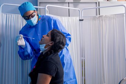 Un trabajador sanitario realiza un test PCR a una mujer en el Centro de Especialidades Carabanchel Alto.