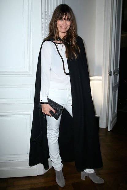 Caroline de Maigret no se quiso perder la fiesta de Mytheresa en París. La polifacética francesa rompió la normalidad de un look de camisa y pantalones blancos con una capa XL.