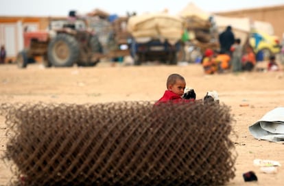 A displaced Syrian child, who fled the countryside surrounding the Islamic State (IS) group stronghold of Raqa, looks on at a temporary camp in the village of Ain Issa on April 28, 2017. / AFP PHOTO / DELIL SOULEIMAN