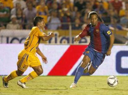 El brasileño Ronaldinho conduce el balón ante el colombiano John Restrepo en el partido disputado hoy en el estadio Universitario de Monterrey en México.