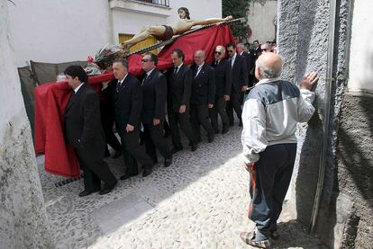 Un hombre observa la procesión de la cofradía de El Cristo del Silencio en Granada.