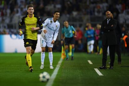 El jugador del Real Madrid, Cristiano Ronaldo, y el entrenador del Borussia de Dortmund Peter Bosz observan si el balón cruza la línea de banda o no durante una jugada del partido.