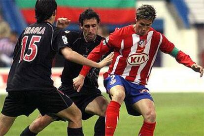 Torres controla la pelota entre Iraola y Luis Prieto.