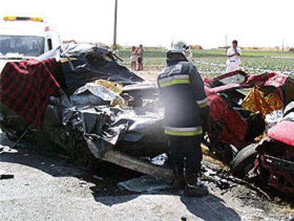 Un bombero observa los restos de los dos turismos que chocaron el domingo en la M-405.