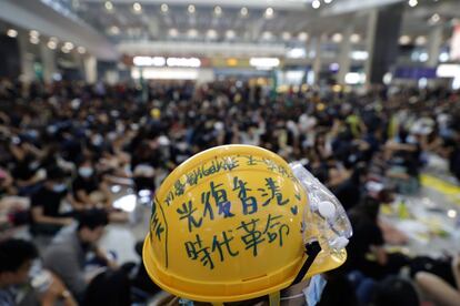 Un manifestante usa un casco que dice: "Recuperar Hong Kong, la revolución de una era" durante una protesta en el aeropuerto de Hong Kong, el 9 de agosto de 2019. Activistas en favor de la democracia organizaron una gran sentada en el área de llegadas del aeropuerto este viernes. Esta es la primera de las acciones que los manifestantes han planeado para el fin de semana, en el que las protestas contra el Gobierno de Carrie Lam continuarán por décima semana consecutiva.