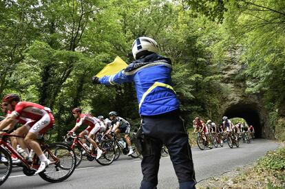 Un gendarme al paso del pelotón entre Rodez y Mende en el Tour 2015.