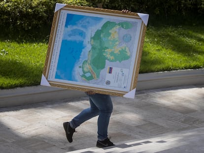 Un hombre carga un mapa de Venezuela con la adhesión del Esequibo, en uno de los jardines del Palacio Federal Legislativo en Caracas el 6 de diciembre.