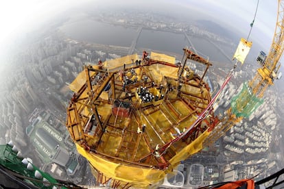 Operarios surcoreanos permanecen en la planta 123 del rascacielos Lotte World Tower durante la fase de finalización de las obras. El exterior del edificio se ha completado tras cinco años y dos meses de obras y se espera que el interior esté terminado para el próximo año.