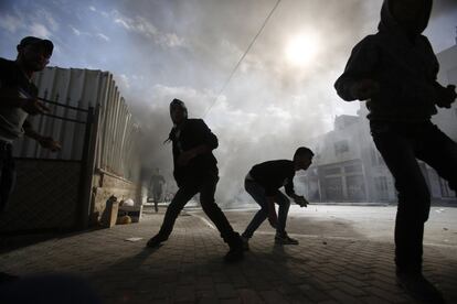 Palestinos se preparan para lanzar piedras a soldados israelíes durante los enfrentamientos en Hebrón (Cisjordania).