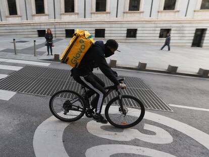 Un ciclista repartidor de Glovo por la Carrera de San Jerónimo de Madrid.