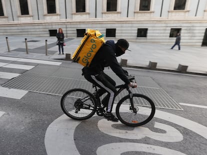 Un ciclista repartidor de Glovo por la Carrera de San Jerónimo de Madrid.