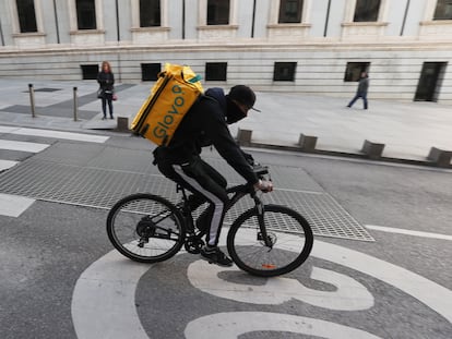 Un ciclista repartidor de Glovo por la Carrera de San Jerónimo de Madrid.