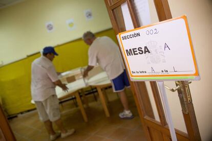 Dos operarios preparan las urnas y demás elementos en un colegio electoral el pasado día 26.