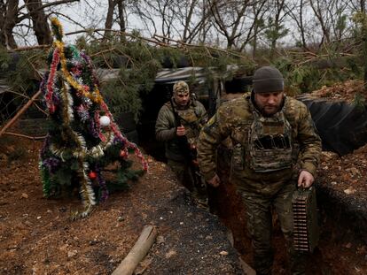Soldados ucranios, en una trinchera en Dnipró junto a la que han levantado un árbol de Navidad, el día 24.