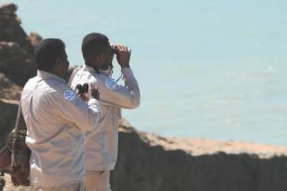 Arriba, trabajos de mantenimiento de una cámara de vigilancia en una cueva. Abajo, agentes de conservación observan la costa.