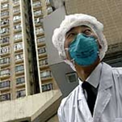 Un policía vigila un edificio de Hong Kong puesto en cuarentena por ser un foco de neumonía.