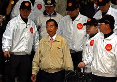 El presidente Chen Shui Bian sale, rodeado de guardaespaldas, del colegio electoral en el que votó ayer.
