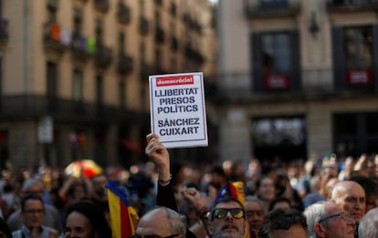 Un home amb una pancarta on es llegeix "Llibertat per als presos polítics, Sànchez i Cuixart" durant la concentració a la plaça Sant Jaume per protestar contra el seu empresonament.