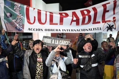 Detractores de Uribe celebran la condena al exmandatario colombiano, afuera de los juzgados de Paloquemao, en Bogotá, este lunes.