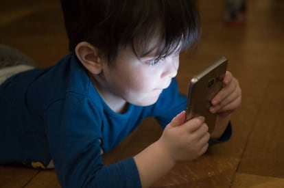 Un niño juega con el teléfono móvil.