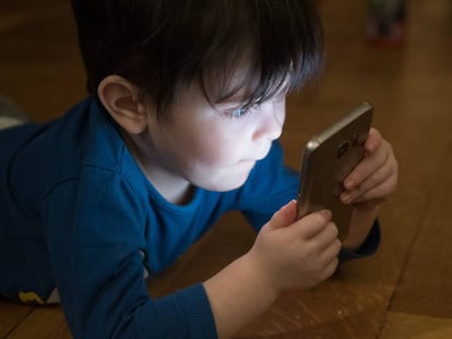 Un niño juega con el teléfono móvil.