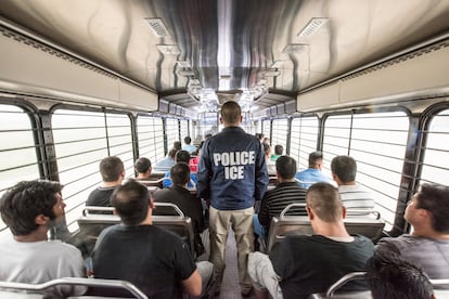 Un agente escolta a extranjeros que se dirigen a un centro de detención de ICE en Chicago.