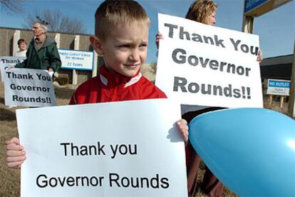 Varios manifestantes, entre ellos un niño, dan las gracias al gobernador de Dakota del Norte, Mike Rounds, por la ley.