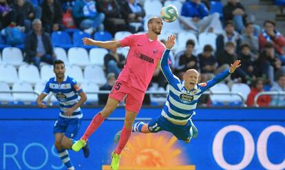 Víctor Mollejo, delantero del Deportivo, cae ante un rival durante un partido en Riazor.