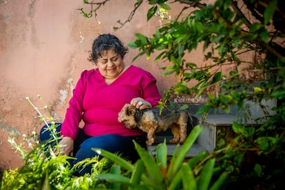 Regina acaricia a uno de sus perros en el patio de su casa, en Cruzeiro, a medio camino entre São Paulo y Río, el 28 de agosto. 