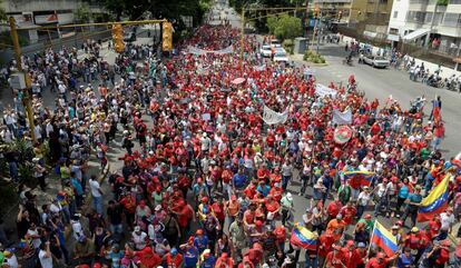 Manifestantes en apoyo al gobierno del presidente Nicolás Maduro (centro) marchan hacia el centro de Caracas mientras los manifestantes anti gubernamentales (izquierda) les gritan consignas.