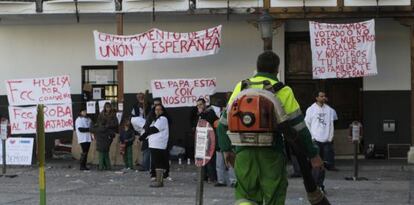 Un empleado de limpiezas pasa por delante de la acampada.