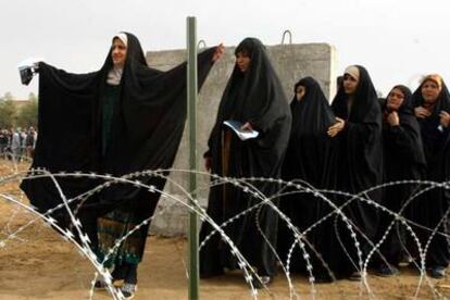 Una mujer iraquí levanta los brazos para ser cacheada antes de votar en la provincia de Al Anbar.