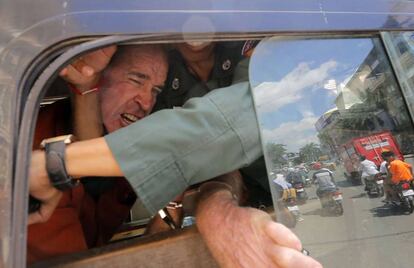El cineasta australiano James Ricketson es bloqueado por un policía camboyano al interior de una camioneta durante su traslado desde el Tribunal municipal en Phnom Penh, Camboya, este viernes. 