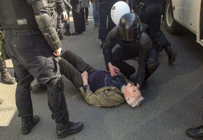 Um policial antidistúrbio atende um manifestante que está no chão durante os protestos de 1º de maio em São Petersburgo (Rússia).