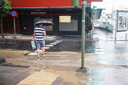 Las autoridades decretaron la alerta máxima y habían advertido a la población de que se evitaran desplazamientos en coche y se extremaran las precauciones. En la foto, una persona cruza una calle anegada en Las Palmas de Gran Canaria.