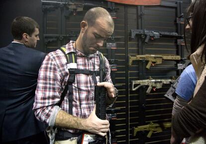 Un asistente a la feria de armas de Las Vegas revisa un rifle.